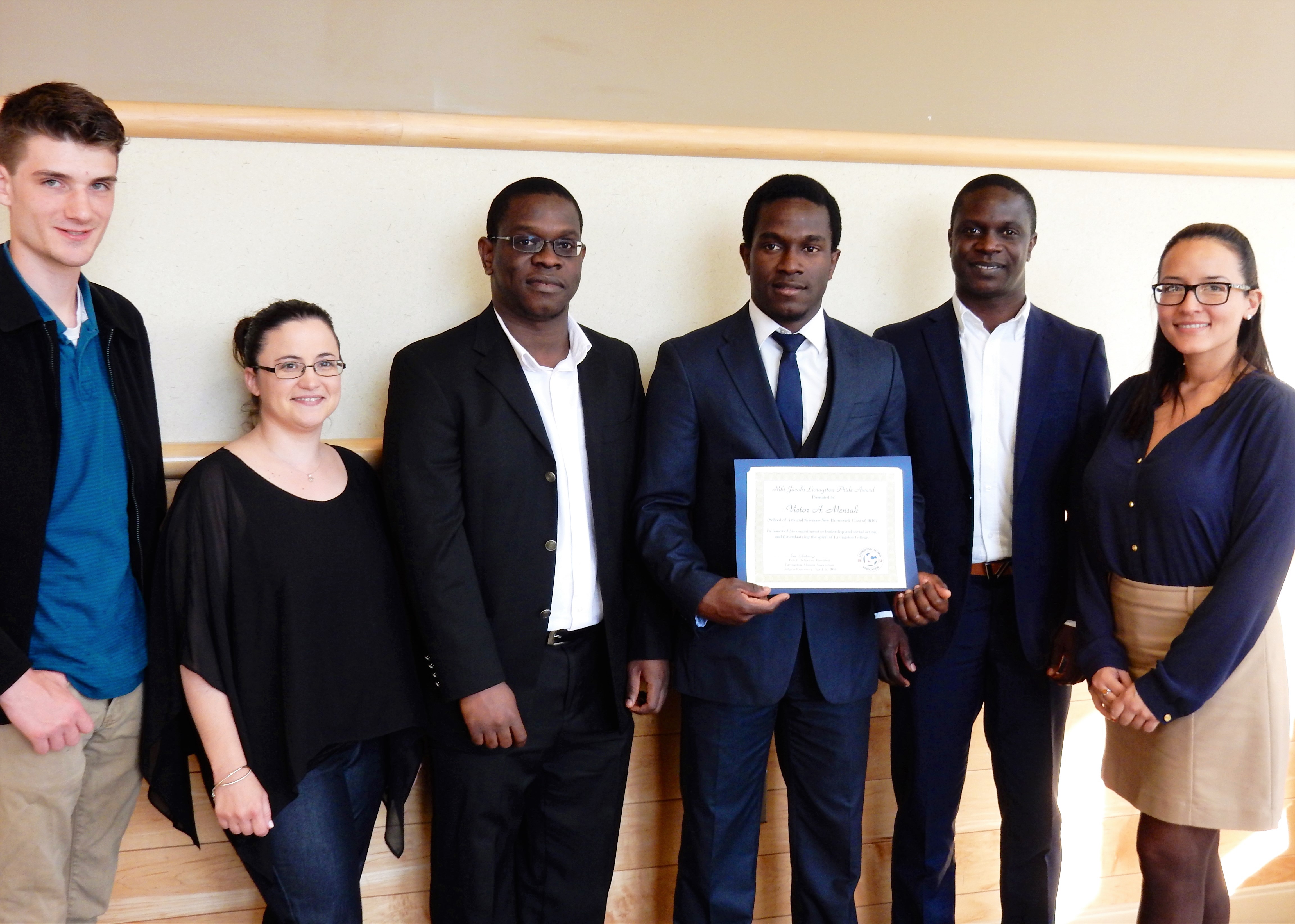 Victor A. Mensah (fourth from left, holding award certificate) with friends and family